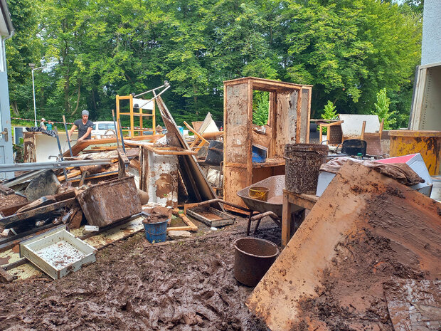 Mit Schlamm verschmierte Möbel vor dem Gebäude 